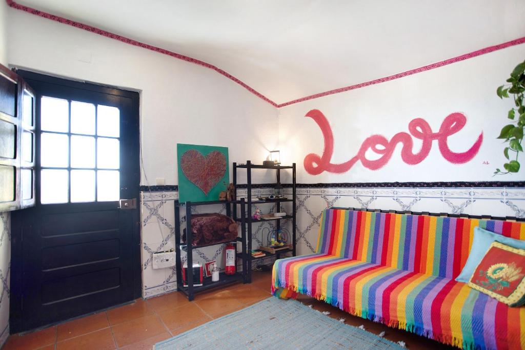 a living room with a couch and a love sign on the wall at Love Temple in Ericeira