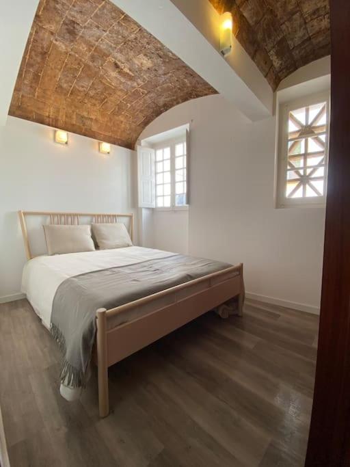 1 dormitorio con 1 cama grande y 2 ventanas en Casa Antunes en Évora