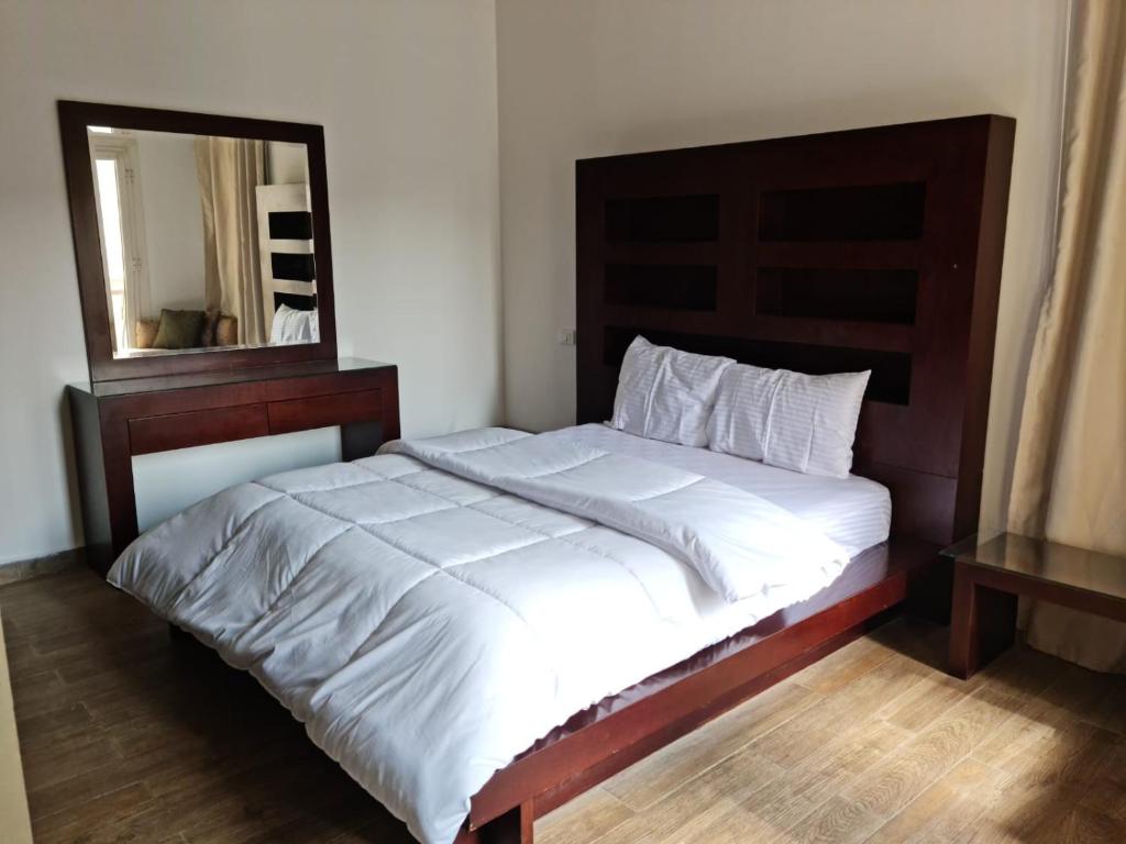 a bedroom with a large bed with a mirror at Two Bedroom Luxury Apartment in New Cairo in Cairo