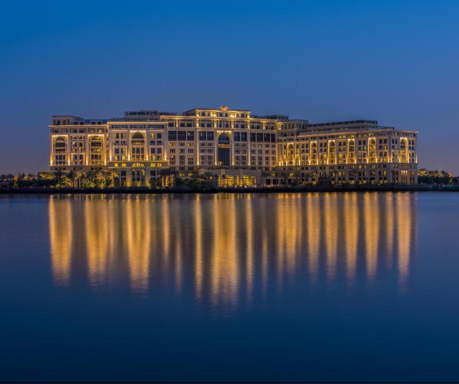 بلازو فيرساتشي دبي في دبي: مبنى كبير الجلوس على الماء في الليل