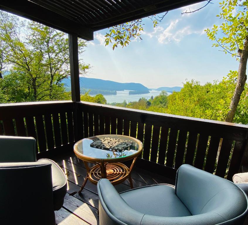 una terraza con sillas y una mesa y vistas al agua en Szegfű33 Vendégház, en Zebegény