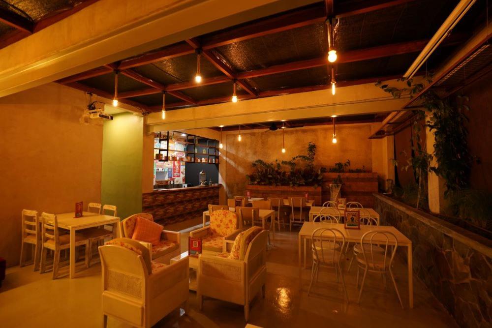 un restaurant avec des tables et des chaises ainsi qu'un bar dans l'établissement BELVA huis, à Bogor