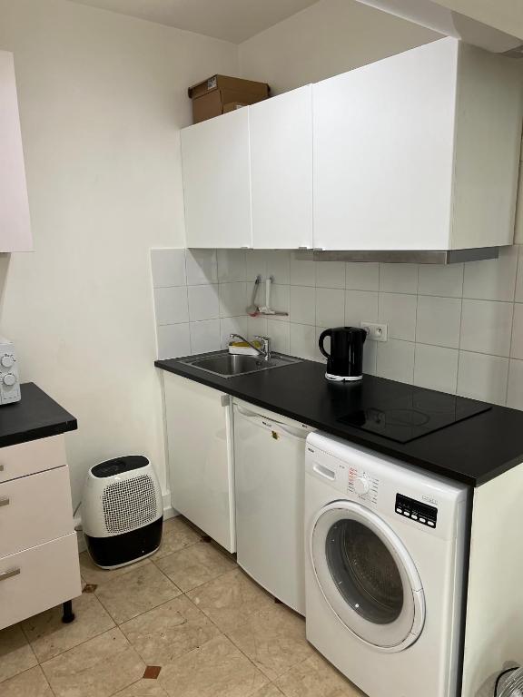 une cuisine avec une machine à laver et un évier dans l'établissement Studio butte aux cailles, à Paris