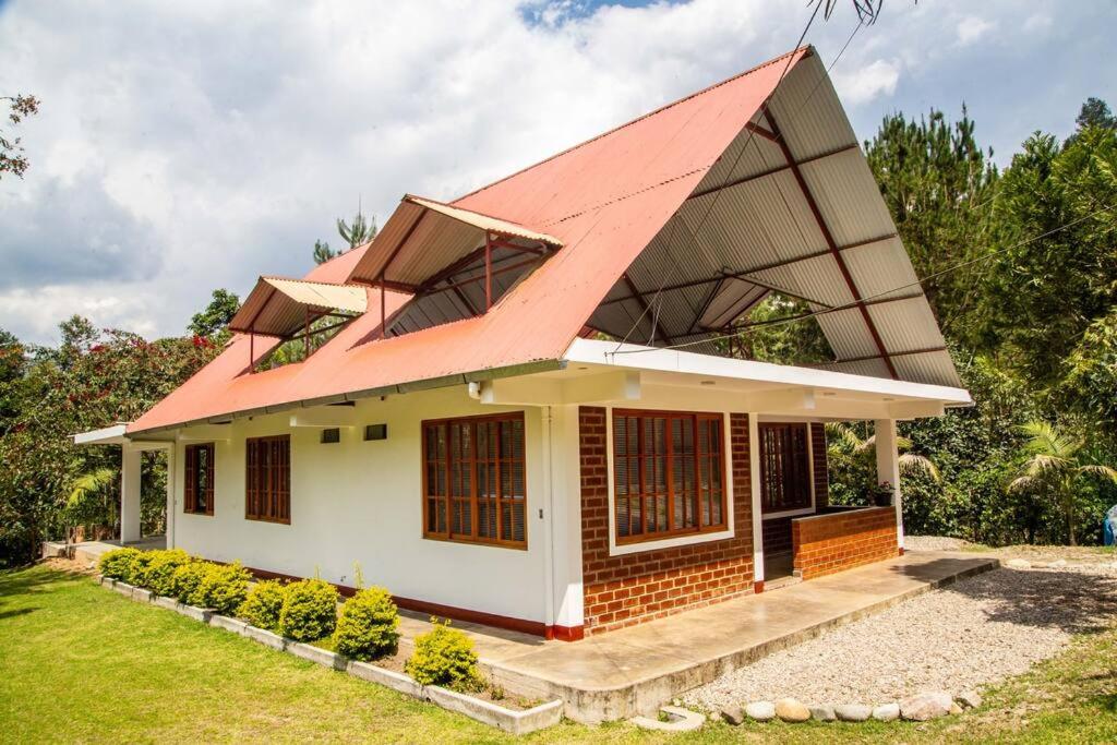 オクサパンパにあるCasa de campo Oro Verde Oxapampaの赤屋根の小屋