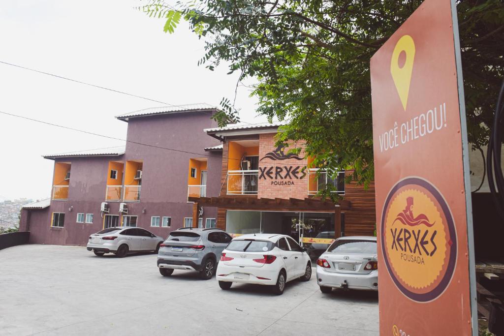 un estacionamiento con autos estacionados frente a un edificio en Pousada Xerxes, en Arraial do Cabo