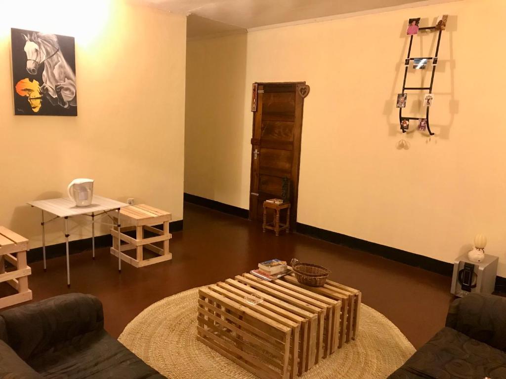 Nomads nest safari house في أروشا: غرفة معيشة مع أريكة وطاولة
