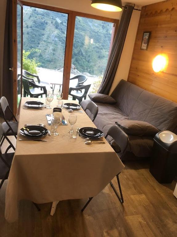 Cette chambre comprend une table avec des verres à vin et un canapé. dans l'établissement VALMEINIER 1800, à Valmeinier