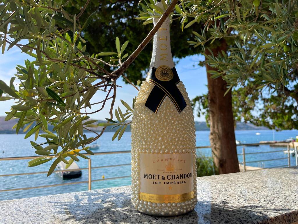 a bottle of wine sitting on top of a table at Villa Olivija-direkt am Strand! in Stara Novalja