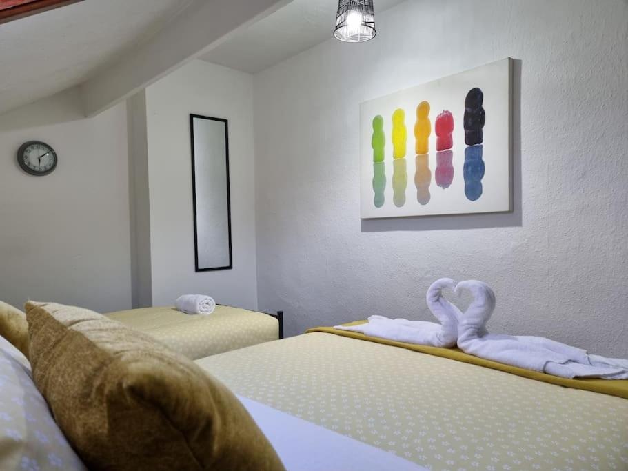 a bedroom with two beds with towels and a painting at Be our Guest! Stylish-Free parking-Central location in Headingley