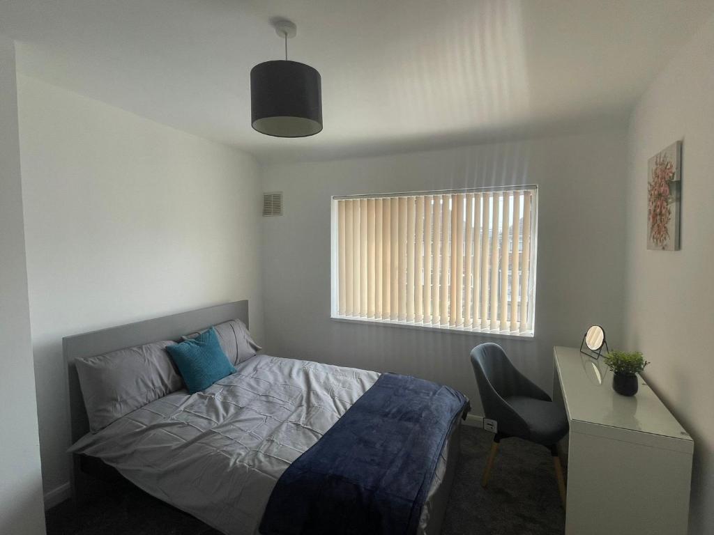 バーミンガムにあるCorporate Stay - 4 Bedroom in Birminghamのベッドルーム1室(ベッド1台、デスク、窓付)