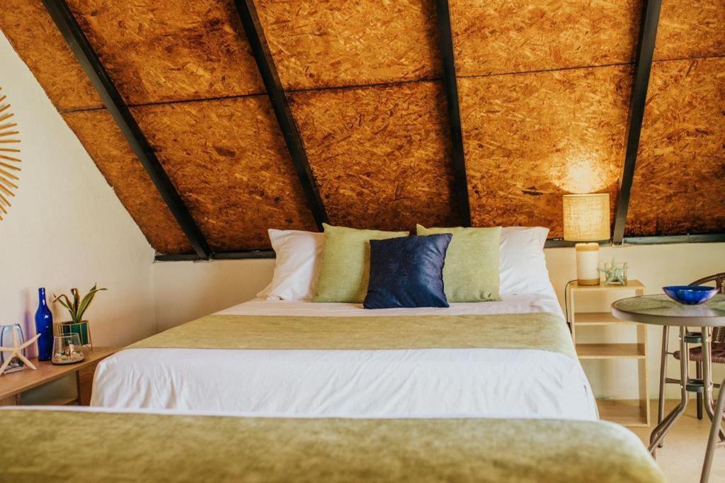 ein Schlafzimmer mit einem großen Bett und einer Holzdecke in der Unterkunft Los Olivos La Playa Hotel y Restaurante in Escuintla