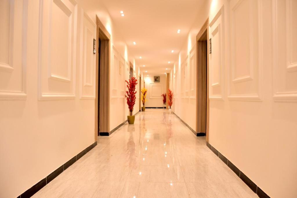un pasillo con paredes blancas y un largo pasillo con suelos blancos en فندق نجران ول ان en Najrán