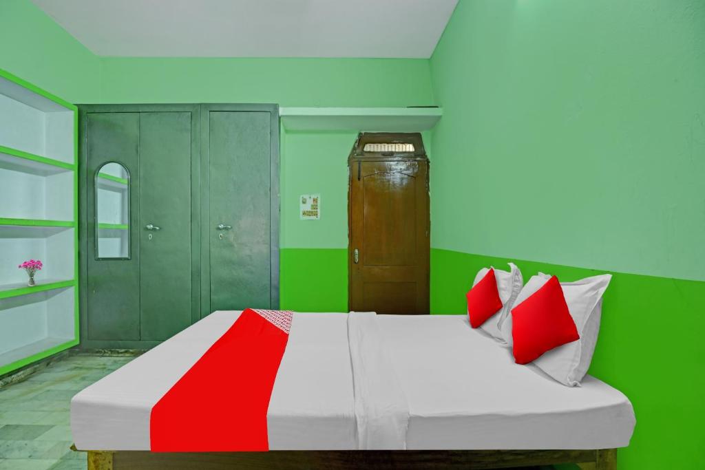 - une chambre avec un lit aux murs rouges et verts dans l'établissement OYO Flagship Hotel Baba''s House, à Kakarmatha
