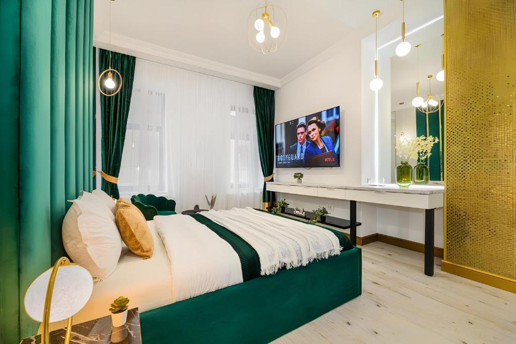 a bedroom with a bed and a desk and a television at Golden Greens Studio - Luxury Design & Self Check-in in Braşov