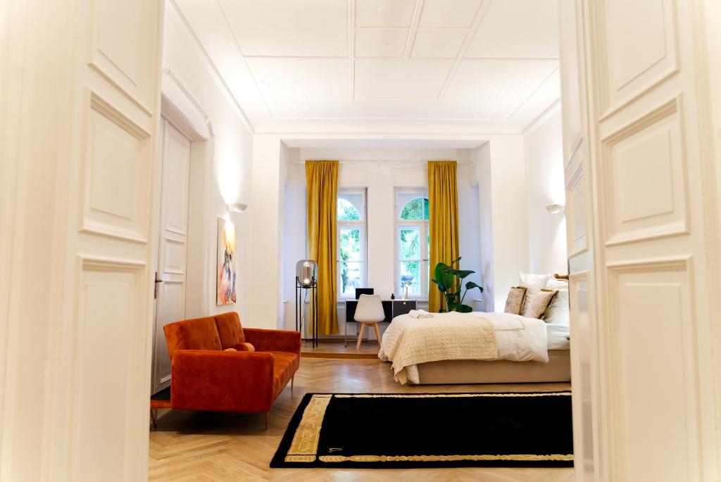 a bedroom with a bed and a red chair at The Gallery in Munich