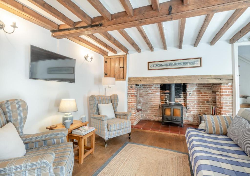 a living room with two couches and a fireplace at 1 Cutty Sark Cottages in West Runton