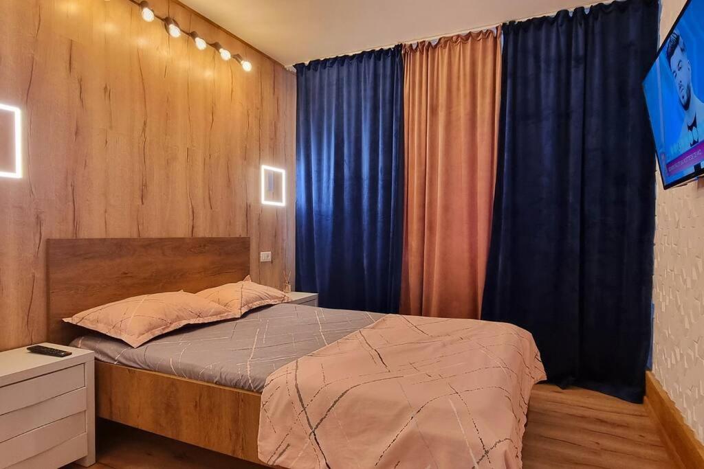a bedroom with a bed with blue curtains at Urban Retreat Barlad in Bîrlad