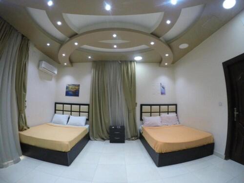 2 camas en un dormitorio con techo artesonado en Panorama New City, en El Cairo