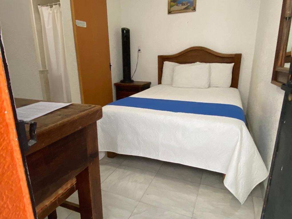 a bedroom with a bed with a blue and white blanket at Hotel Nacional in Oaxaca City