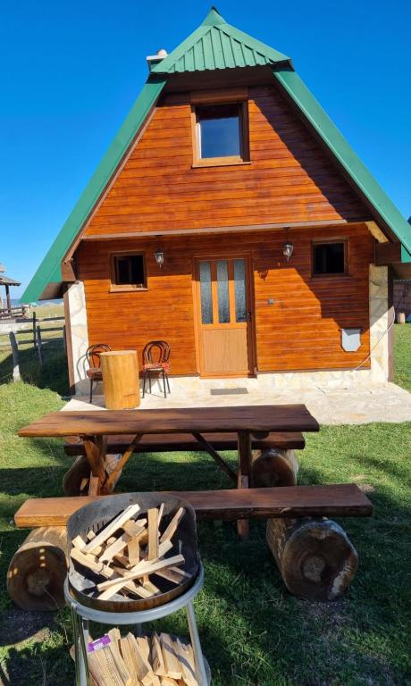 Mountain house في زبلجك: كابينة خشب أمامها طاولة نزهة