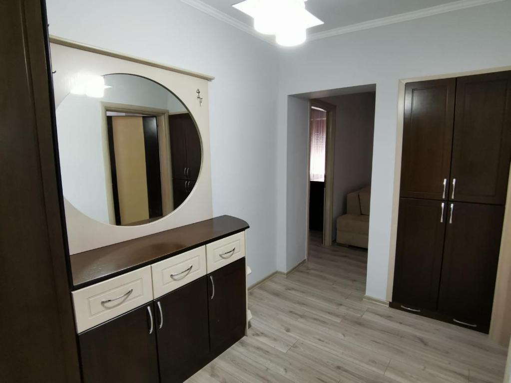 uma casa de banho com um lavatório e um espelho na parede em Relaxing Getaway em Gjirokastër
