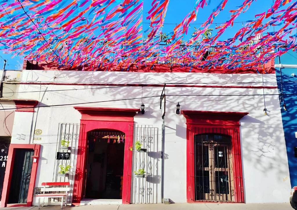 a white building with red trim and red doors at Posada Don Mario in Oaxaca City