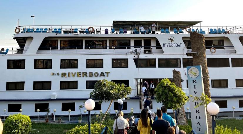 Ein großes weißes Kreuzfahrtschiff mit Leuten, die darauf stehen. in der Unterkunft مركب ريفر River Boat in Kairo