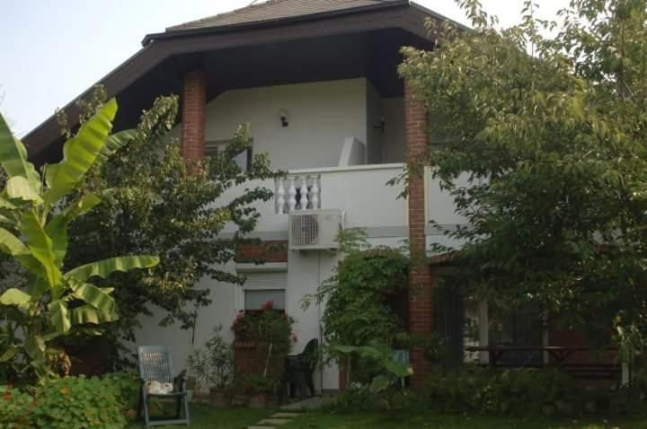 uma casa branca com varanda e árvores em Apartments Sončnica em Moravske Toplice