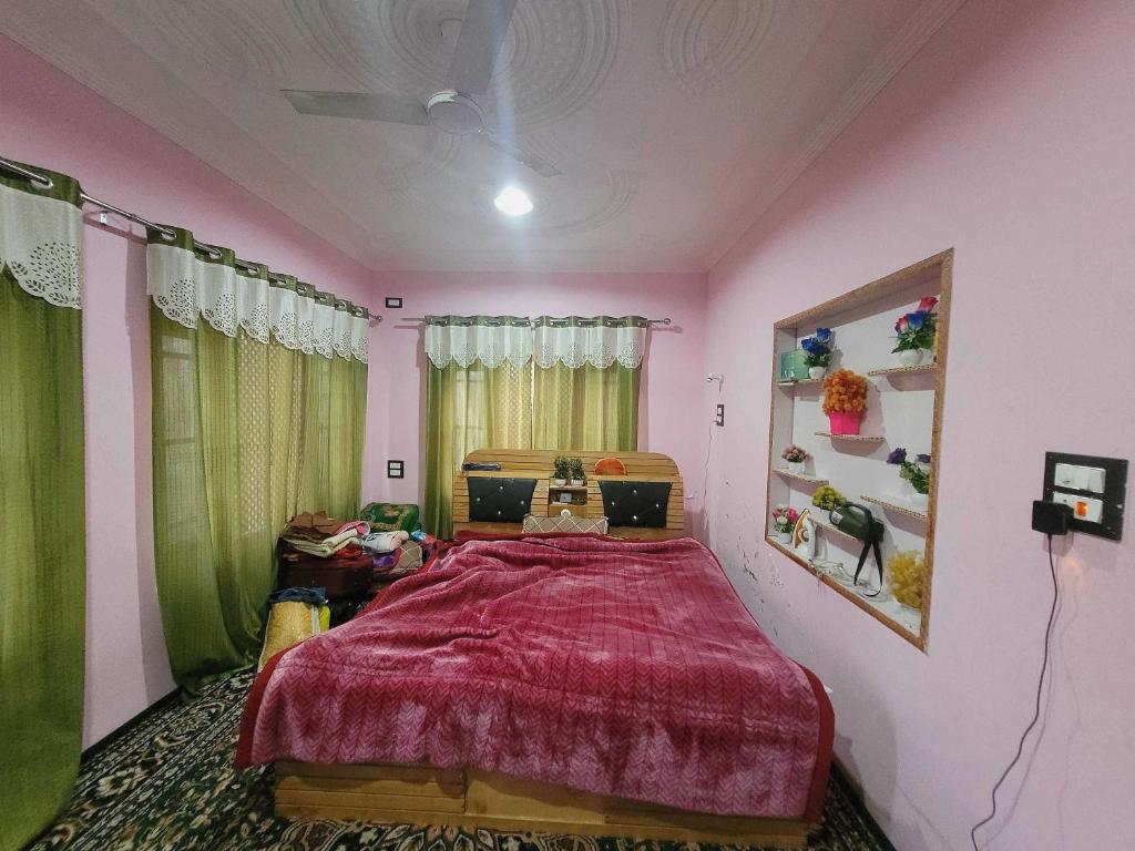 a bedroom with a large bed with a red bedspread at OYO Home Aalim Homestay 