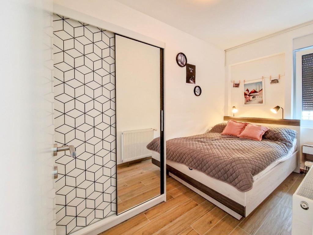 um quarto com uma cama e uma porta de duche envidraçada em Kirabela Apartment em Zagreb