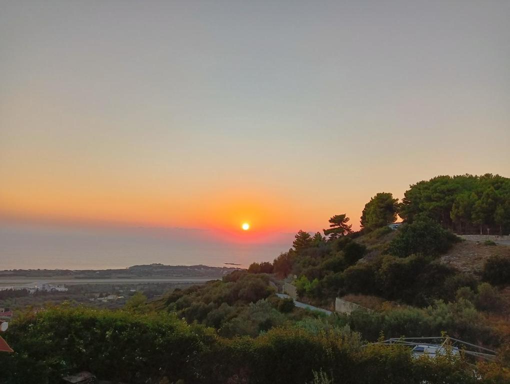 een zonsondergang op een heuvel met zonsondergang bij Irida's house in Kefallonia