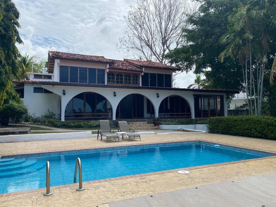 una casa con piscina frente a una casa en Coronado Beachfront tropical home!, en Playa Coronado