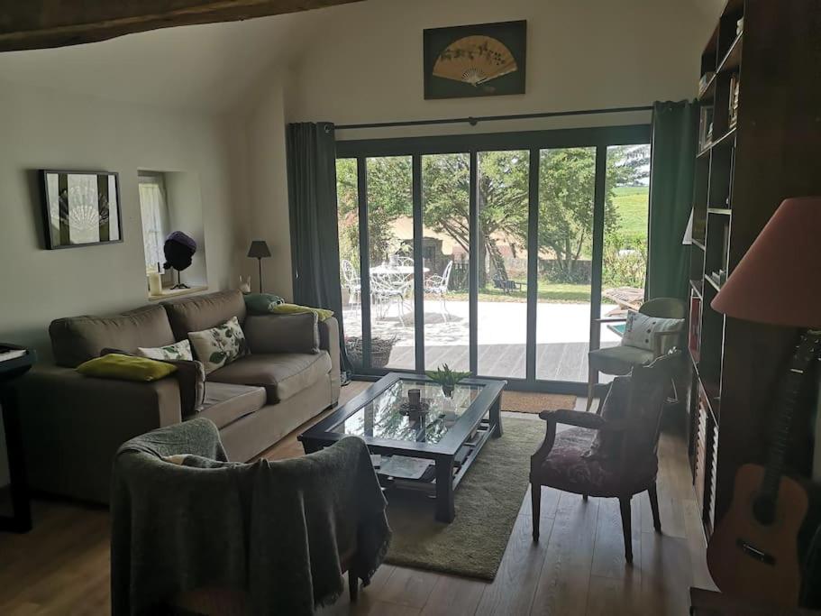 ein Wohnzimmer mit einem Sofa und einem Tisch in der Unterkunft Au cœur de Mortagne, un balcon sur le Perche in Mortagne-au-Perche