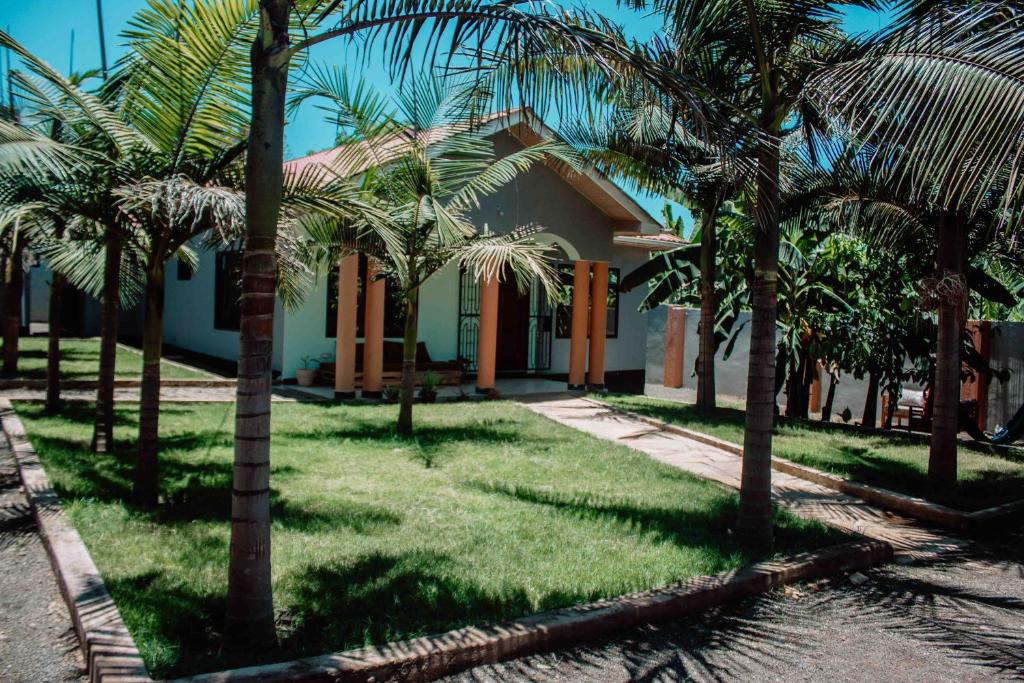 una casa con palmeras delante en Tropicana House, en Arusha