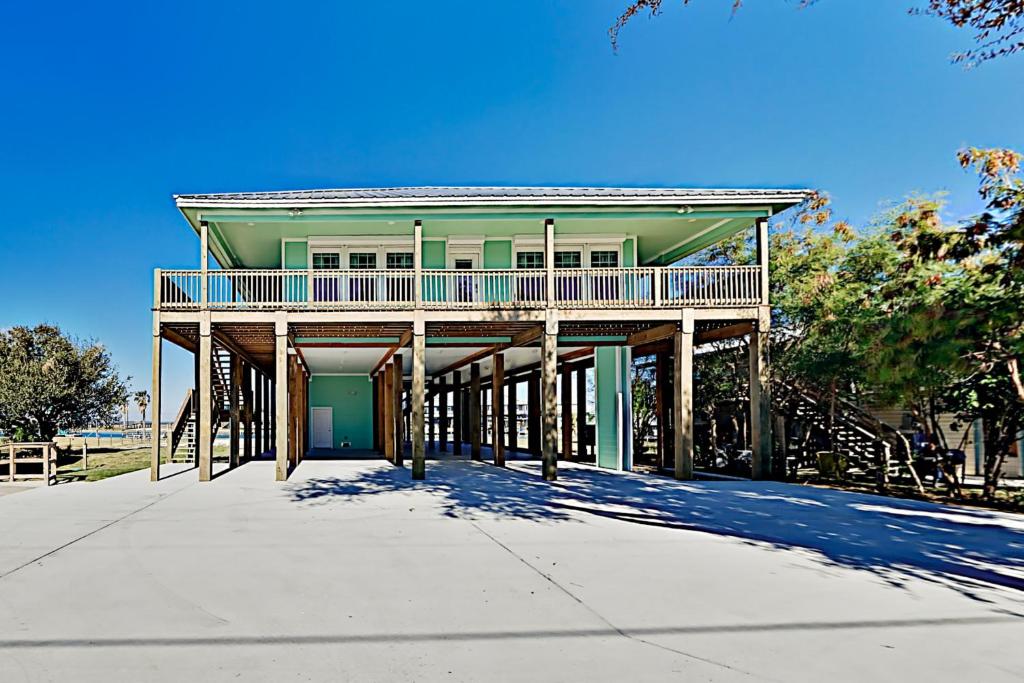 a large house with a deck on a sidewalk at Copano Ridge Dream A in Rockport