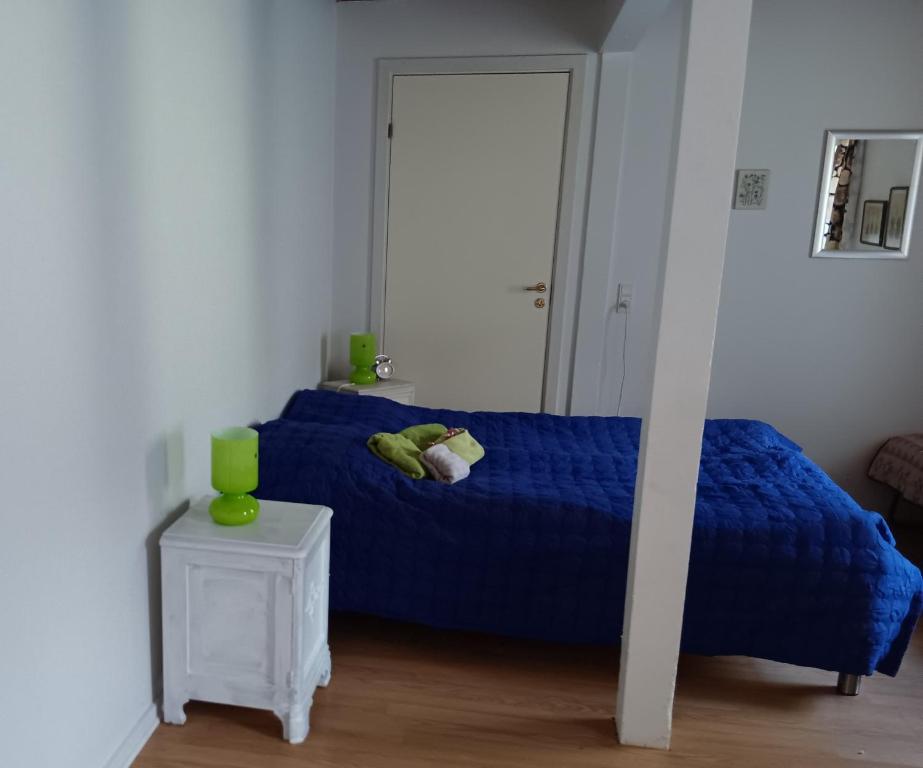 Schlafzimmer mit einem blauen Bett und einem Tisch in der Unterkunft Bøelgaarden in Gørding
