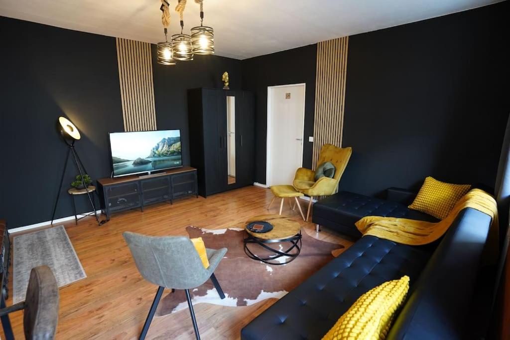 ein Wohnzimmer mit einem Sofa, Stühlen und einem TV in der Unterkunft Downtown/Balcony/Coffee Bar/TV-Streaming/top WLAN in Bielefeld