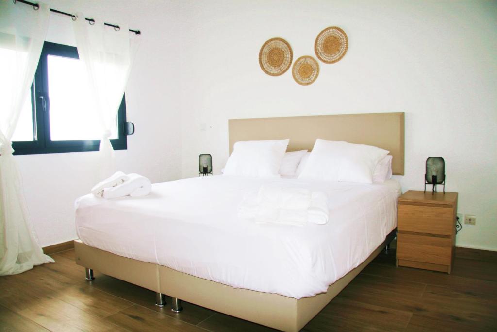 a bedroom with a large white bed and a window at DakarByDays-DBD004-Appartement Amina 3 chambres in Dakar