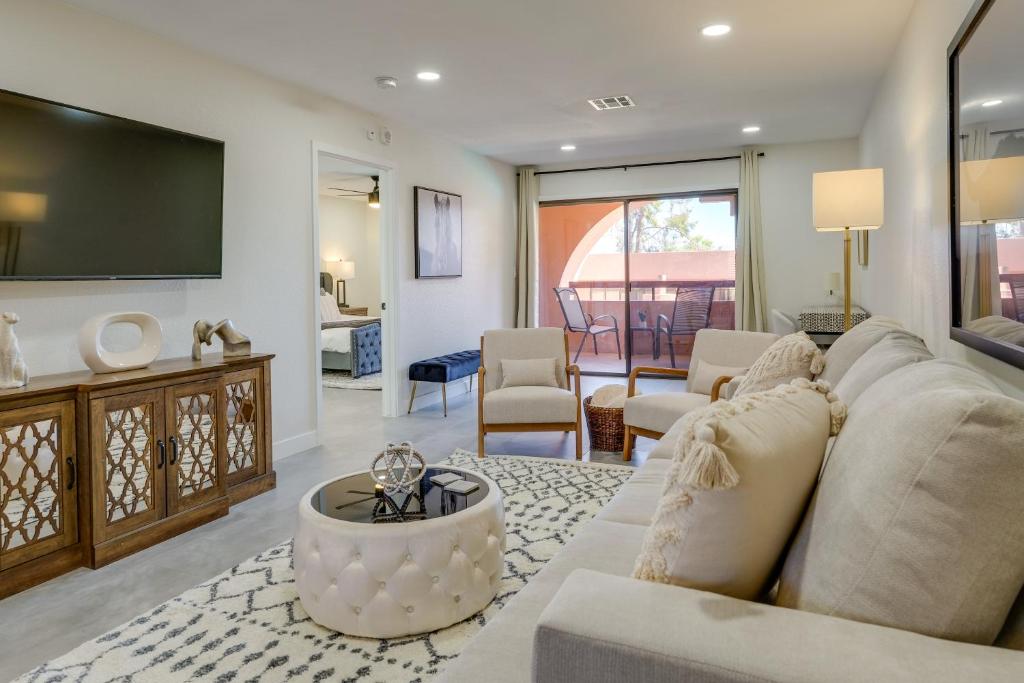 a living room with a couch and a tv at Fully Renovated Phoenix Condo with Pool-View Balcony in Phoenix