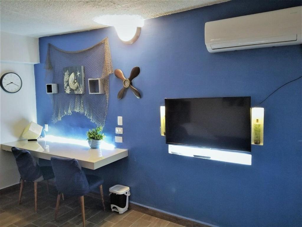 una camera con una parete blu e una grande TV a schermo piatto di Regiotepec a Monterrey