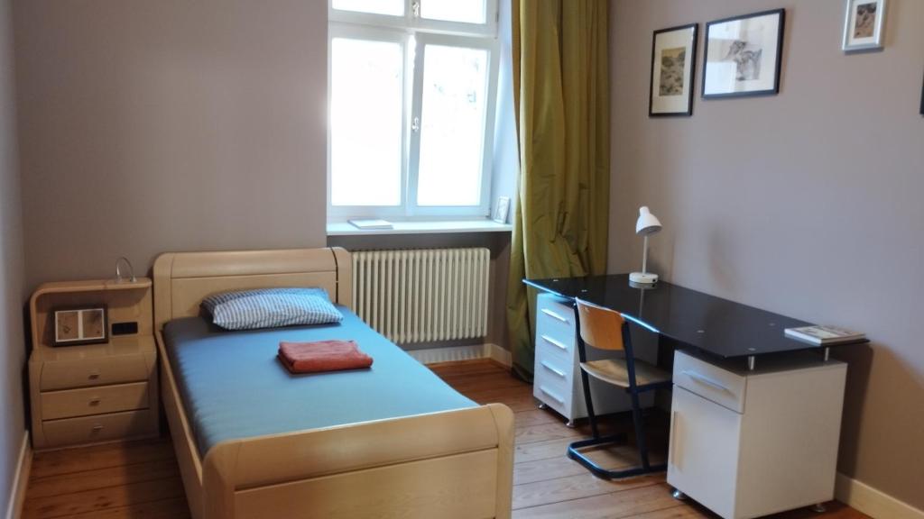 ein kleines Schlafzimmer mit einem Bett und einem Schreibtisch in der Unterkunft Stadthaus Room 2 mit Hochbett for 3 Persons or Eltern mit 2 Kindern in Mannheim