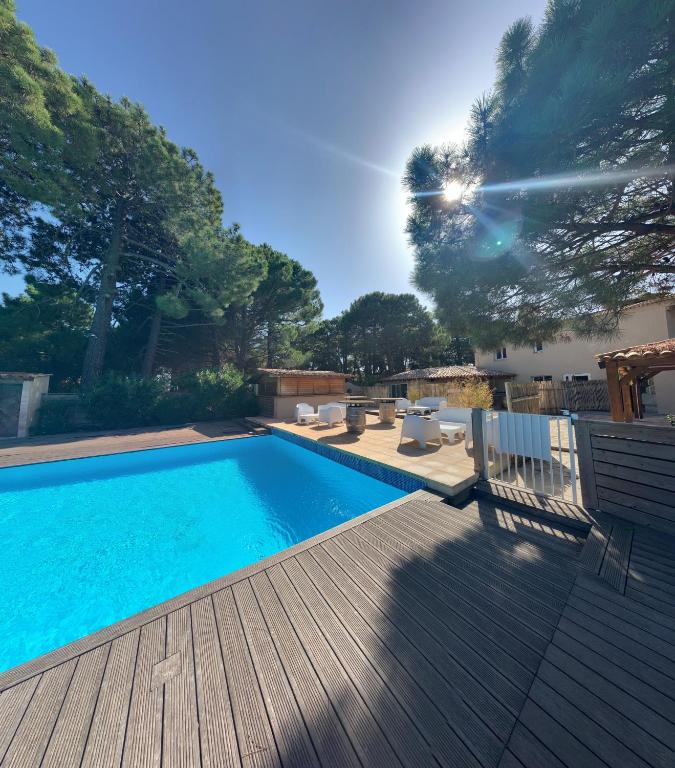 - une piscine sur une terrasse à côté d'une terrasse en bois dans l'établissement Cala Rossa, Lecci - villa 5 minutes de la très belle plage de Cala Rossa, à Lecci
