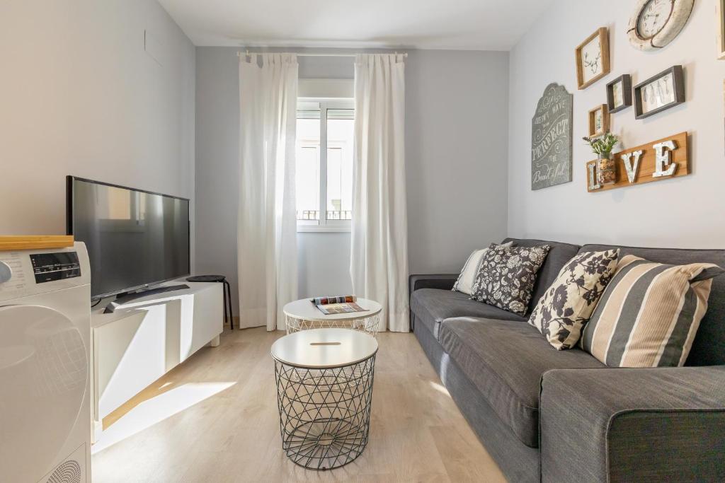 uma sala de estar com um sofá e uma televisão em Charming 2 Bedroom Apartment at Rodrigo de Triana By Oui Seville em Sevilha