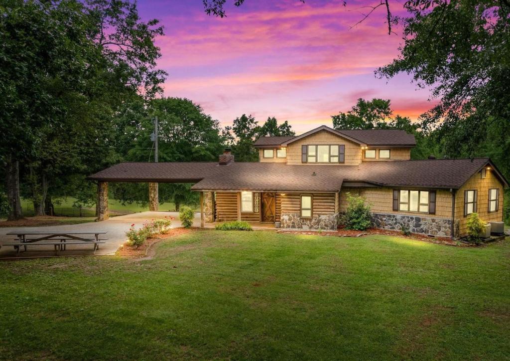 a house with a picnic table in the yard at Refuge Ranch Retreat Log Cabin Lake 53+ Acres in Locust Grove