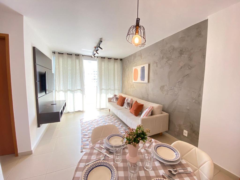 a living room with a couch and a table at Aconchegante apto 2/4 Setor Bueno 1307 in Goiânia
