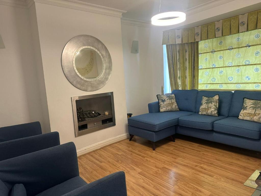 a living room with a blue couch and a fireplace at 2 Bed Mill Hill Flat in Mill Hill
