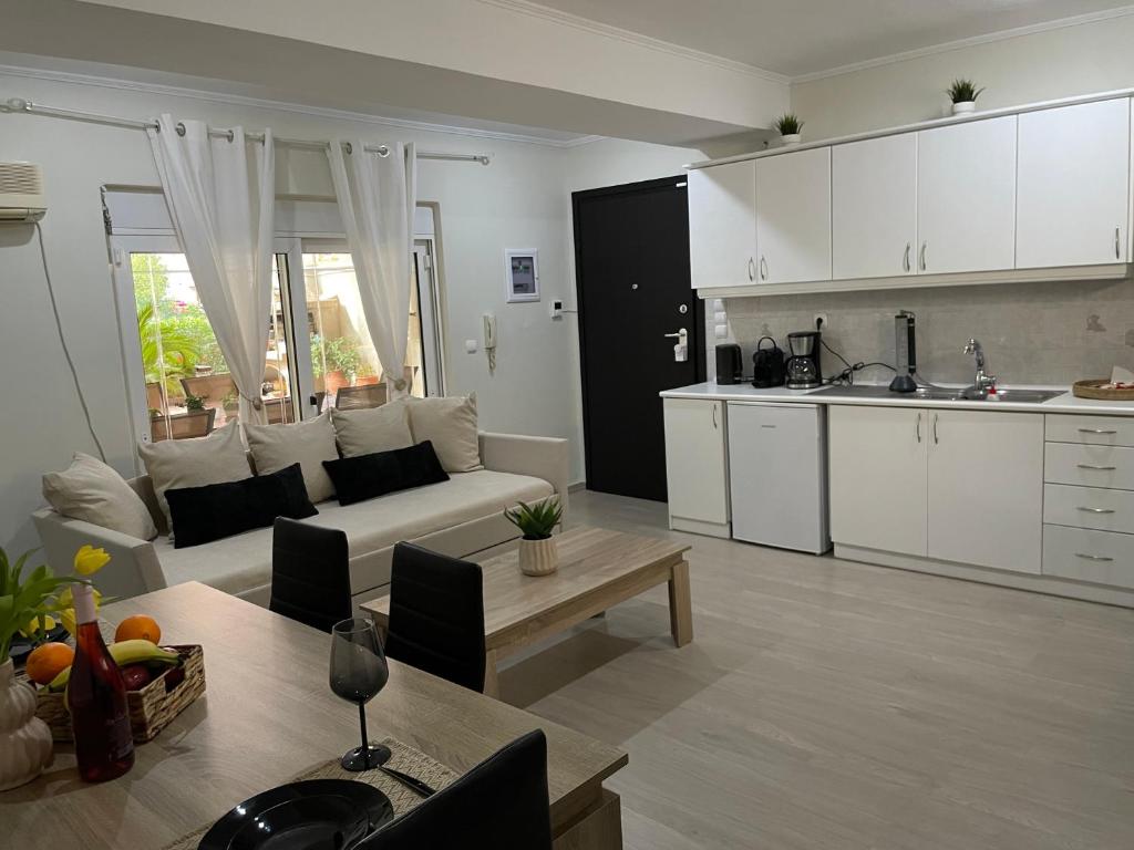 een keuken en een woonkamer met een bank en een tafel bij Triptolemus Stay Inn in Elefsina