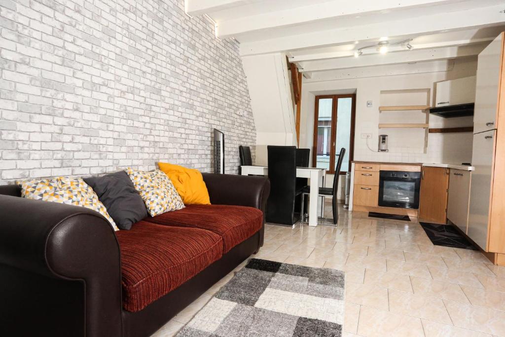 uma sala de estar com um sofá e uma parede de tijolos em Maison hyper centre Romilly-sur-Seine em Romilly-sur-Seine