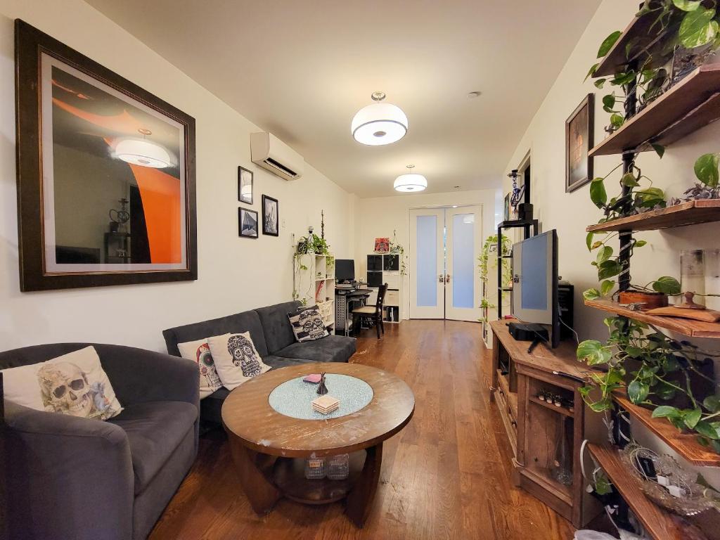 uma sala de estar com um sofá e uma mesa em Homestyle Haven by the Water em Brooklyn