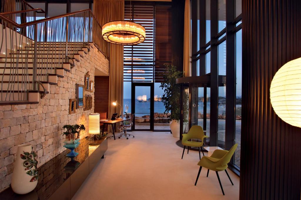 a lobby with chairs and tables in a building at Martinhal Sagres Beach Family Resort Hotel in Sagres